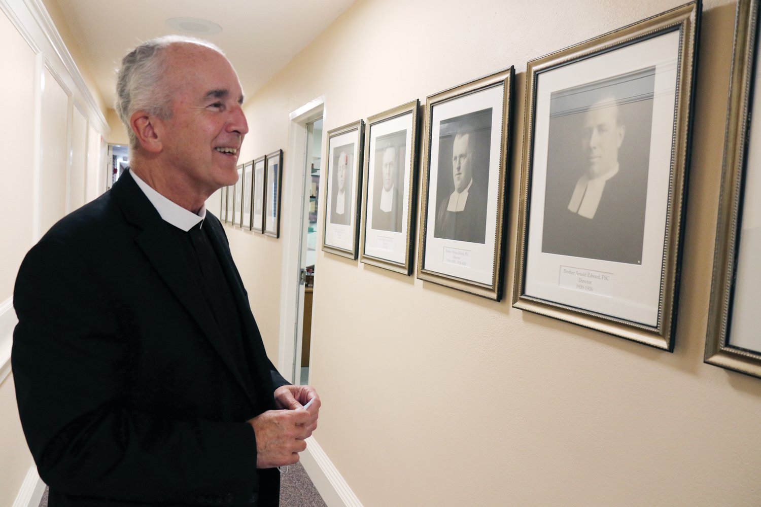 Brother Dennis Malloy, FSC, looks at portraits of past presidents.